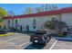 Townhouse featuring a parking space, mature landscaping and a red tile roof in a well-maintained community at 2700 Bayshore Blvd # 1E, Dunedin, FL 34698