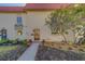 Charming townhouse featuring a well-maintained front yard with mulch beds, flowers, and a sidewalk to the front door at 2700 Bayshore Blvd # 1E, Dunedin, FL 34698