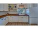 Well-lit kitchen with white cabinets, wooden countertops, modern appliances, and a view from the window at 2700 Bayshore Blvd # 1E, Dunedin, FL 34698