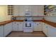 Charming kitchen featuring white cabinets, wooden counters, modern appliances, and ample storage space at 2700 Bayshore Blvd # 1E, Dunedin, FL 34698