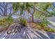 Charming outdoor brick patio featuring mature trees, secure fencing, and bicycle parking at 2700 Bayshore Blvd # 1E, Dunedin, FL 34698