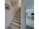 Bright, modern staircase leading to a spacious living area with beautiful wood floors at 2700 Bayshore Blvd # 1E, Dunedin, FL 34698