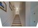 Bright stairway features a light wood staircase and white walls adorned with framed pictures at 2700 Bayshore Blvd # 1E, Dunedin, FL 34698