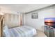 Well-lit bedroom with plush carpet, storage, and entertainment setup for relaxation and convenience at 400 Island Way # 1708, Clearwater Beach, FL 33767