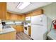 A functional kitchenette with light wood cabinets, essential appliances, and a clean, efficient layout at 400 Island Way # 1708, Clearwater Beach, FL 33767