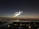 Picturesque night view of a waterfront neighborhood showcasing city lights reflecting on the water under a captivating evening sky at 400 Island Way # 1708, Clearwater Beach, FL 33767
