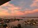 Scenic waterfront neighborhood view at sunset featuring serene water, homes, and a sky illuminated with pastel colors at 400 Island Way # 1708, Clearwater Beach, FL 33767