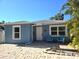 Charming blue single-story home with brick driveway and inviting front porch seating area at 4500 23Rd S Ave, St Petersburg, FL 33711