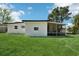 Well-maintained backyard with a white house, lush lawn and an enclosed porch for outdoor enjoyment at 5108 Tangelo Dr, New Port Richey, FL 34652