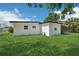 Well-maintained backyard with a white house, lush lawn and an enclosed porch for outdoor enjoyment at 5108 Tangelo Dr, New Port Richey, FL 34652