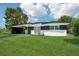 Charming single-story home with black and white accent paint and a lush green lawn at 5108 Tangelo Dr, New Port Richey, FL 34652