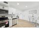 Bright kitchen and dining area feature stainless appliances, white cabinets, and sleek countertops at 5108 Tangelo Dr, New Port Richey, FL 34652