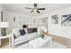 Bright living room with a gray sofa, marble-top coffee table, wood floors, and modern decor for comfortable, stylish living at 5108 Tangelo Dr, New Port Richey, FL 34652