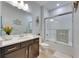 Well-lit bathroom featuring modern vanity, seashell decor, and glass shower at 5236 Wishing Arch Dr, Apollo Beach, FL 33572