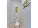 Charming half bathroom with modern toilet, neutral walls, and coastal-themed artwork at 5236 Wishing Arch Dr, Apollo Beach, FL 33572