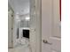 Hallway view into bathroom featuring a tile shower and dark vanity with flower-patterned mats at 5236 Wishing Arch Dr, Apollo Beach, FL 33572