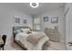 Cozy bedroom with neutral decor, framed artwork, a ceiling fan, and natural light from the window at 5236 Wishing Arch Dr, Apollo Beach, FL 33572
