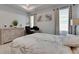 Cozy bedroom with light walls and wood floors, dresser, desk, and neutral decor at 5236 Wishing Arch Dr, Apollo Beach, FL 33572