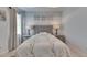 Well-lit bedroom boasts a gray upholstered bed with matching bedside tables and light-colored wood flooring at 5236 Wishing Arch Dr, Apollo Beach, FL 33572