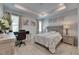 Bright bedroom featuring a tray ceiling, wood floors, a gray upholstered bed and a desk area at 5236 Wishing Arch Dr, Apollo Beach, FL 33572