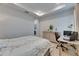 Bedroom with tray ceiling, light walls, desk, and dresser with wood floors at 5236 Wishing Arch Dr, Apollo Beach, FL 33572