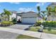 Inviting home exterior featuring a well-kept lawn, lush landscaping, and a convenient two-car garage at 5236 Wishing Arch Dr, Apollo Beach, FL 33572