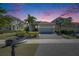 Beautiful home exterior showcasing a well-manicured lawn and a spacious two-car garage under a colorful sky at 5236 Wishing Arch Dr, Apollo Beach, FL 33572