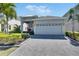 Home featuring a two-car garage, paved driveway, and manicured landscaping at 5236 Wishing Arch Dr, Apollo Beach, FL 33572
