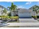 Well-maintained home exterior with lush landscaping, a paved driveway, and a two-car garage at 5236 Wishing Arch Dr, Apollo Beach, FL 33572