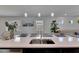 Kitchen island offers a dual sink and seating with views of decor and windows at 5236 Wishing Arch Dr, Apollo Beach, FL 33572