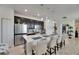 Modern kitchen features a large island with seating, stainless steel appliances, and stylish pendant lighting at 5236 Wishing Arch Dr, Apollo Beach, FL 33572
