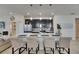 Modern kitchen featuring a large center island with seating, stainless steel appliances, and pendant lighting at 5236 Wishing Arch Dr, Apollo Beach, FL 33572