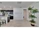 Open concept living space with a kitchen view, modern chandelier, ceramic floors, and natural light at 5236 Wishing Arch Dr, Apollo Beach, FL 33572