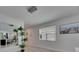 Bright living room featuring an elegant chandelier, large window and beach-themed wall decor at 5236 Wishing Arch Dr, Apollo Beach, FL 33572