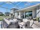 Covered patio featuring wicker seating, outdoor kitchen and views of the backyard at 5236 Wishing Arch Dr, Apollo Beach, FL 33572