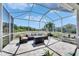Screened patio with comfortable seating overlooking lush landscaping and blue skies at 5236 Wishing Arch Dr, Apollo Beach, FL 33572