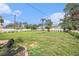 Large backyard features a green lawn, palm trees, and white picket fence, offering a serene outdoor space at 5426 Venetian Ne Blvd, St Petersburg, FL 33703
