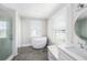 Bright bathroom featuring a standalone tub, large window, and tiled flooring at 5426 Venetian Ne Blvd, St Petersburg, FL 33703