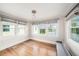 Bright bedroom featuring three windows with gray shades and hardwood flooring at 5426 Venetian Ne Blvd, St Petersburg, FL 33703