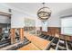 Open-concept dining room in mid-renovation with plywood flooring, chandelier, and view to the kitchen at 5426 Venetian Ne Blvd, St Petersburg, FL 33703