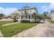 Two-story home featuring a well-manicured lawn, a water fountain, and lush palm trees at 5426 Venetian Ne Blvd, St Petersburg, FL 33703