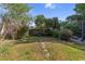 Private backyard with a serene grass area, stone path, mature trees and shrubs, for outdoor enjoyment at 5507 Bluejay Ln, Tampa, FL 33625