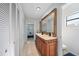 Bathroom with a large, decorative mirror above the double sink vanity and white linen closets at 5507 Bluejay Ln, Tampa, FL 33625