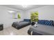 Bedroom featuring two queen beds, tile flooring, and bright windows at 5507 Bluejay Ln, Tampa, FL 33625