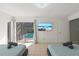 Bright bedroom featuring a view of the pool, tiled floors, and a mounted television for comfortable viewing at 5507 Bluejay Ln, Tampa, FL 33625