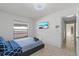 Cozy bedroom with a simple bed frame, tiled floors, and a mounted television for entertainment at 5507 Bluejay Ln, Tampa, FL 33625