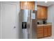 Stainless steel refrigerator complemented by wood cabinetry and granite counters at 5507 Bluejay Ln, Tampa, FL 33625