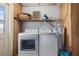 Functional laundry room with modern washer and dryer set, shelving, and utility connections at 5507 Bluejay Ln, Tampa, FL 33625