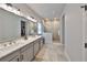 Bathroom featuring double sinks, a walk-in shower with glass doors and modern lighting fixtures at 5523 Del Coronado Dr, Apollo Beach, FL 33572