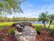 Charming brick patio with string lights overlooking a serene lake view and lush landscaping at 6103 Saint Remy Way, Lutz, FL 33558